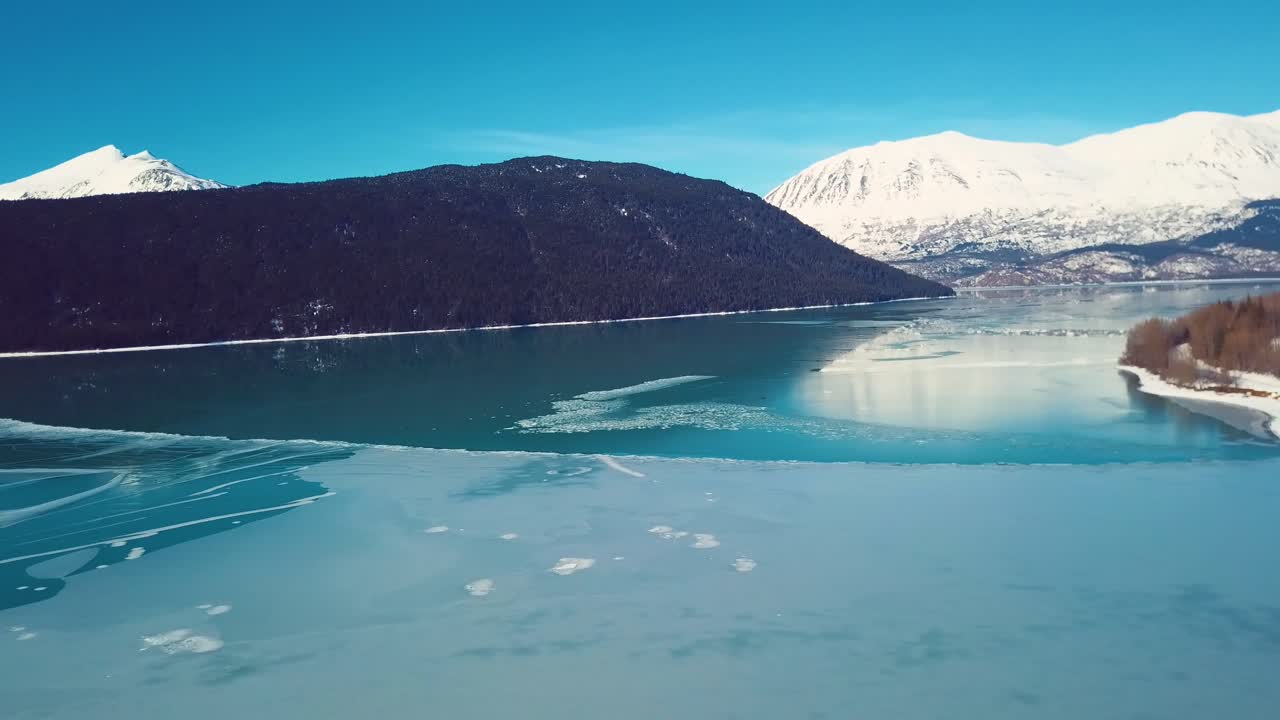 video de drones de 4k de montañas cubiertas de nieve junto a un lago en alaska durante el invierno