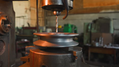 milling machine tool makes hole in round detail in workshop