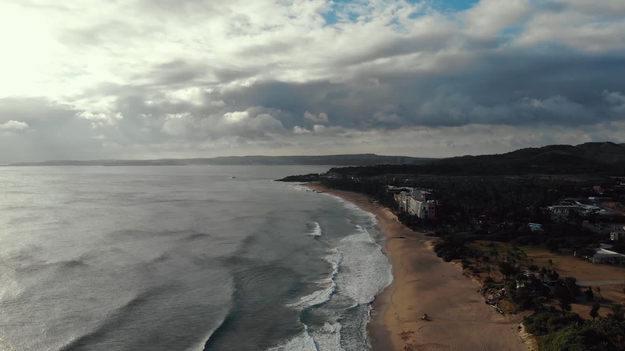 una toma de drones del mar filipino y la playa en el parque nacional de kenting, taiwán con la cámara moviéndose hacia atrás desde la puesta del sol