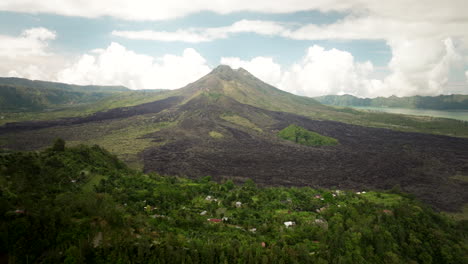 Lush-green-landscape,-rugged-terrain,-mountain-summit,-sky-background