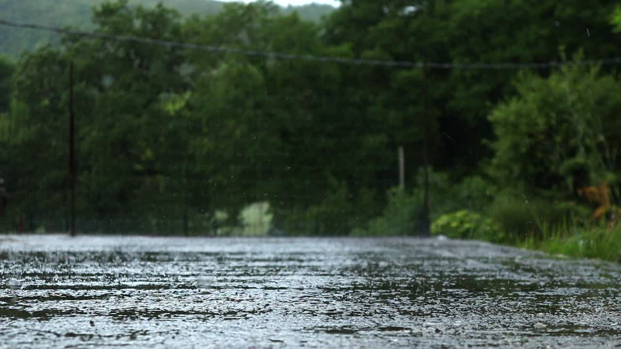 rain drops fall hard on the flooded concrete during a heavy rain in summer
