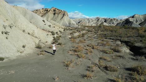 Woman-hike-solo-through-Tabernas-Desert-in-Almeria,-Andalusia,-Spain---Aerial