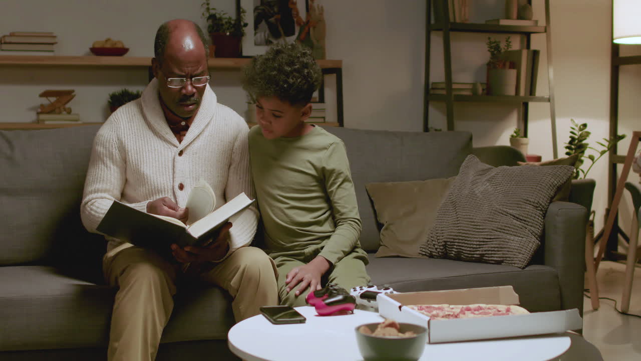 Old black man and boy reading a book