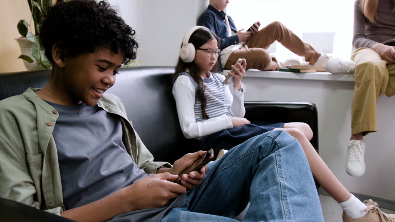Young people engrossed in their smartphones in a lounge area