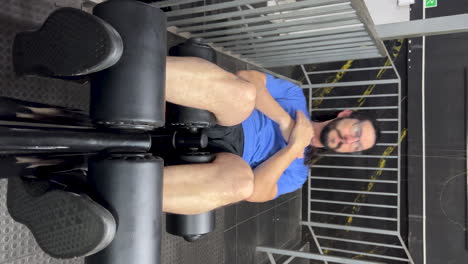 latin man with beard and long hair doing sit-ups on incline bench