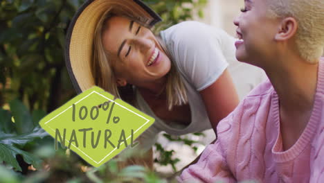 animation of 100 percent natural text over diverse female couple working in garden