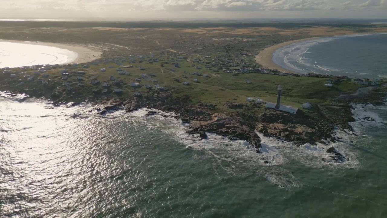 Vue aérienne du paysage marin scintillant de Cabo Polonio et du phare de l'île sur la côte luxuriante de l'Uruguay