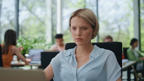 serious woman listening laptop videocall at office closeup. business lady agree
