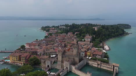 drone shot of the medieval fortress with surrounding historic buildings on the lake peninsula