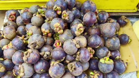 Close-up-shot-of-fresh-purple-mangosteen-fruit-for-sale-at-a-roadside-fruit-stall-in-Kuala-Lumpur,-Malaysia-at-daytime