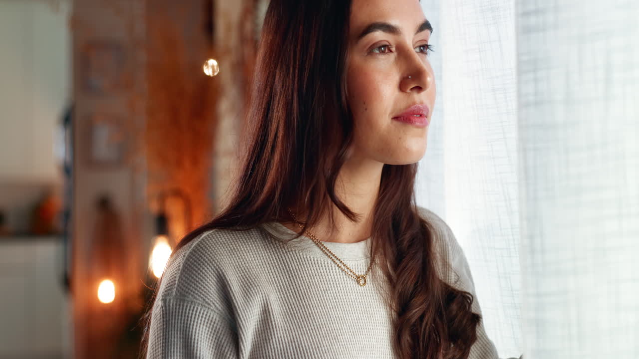 Una mujer mirando por la ventana.