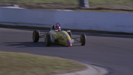 three racing cars race around a track 1