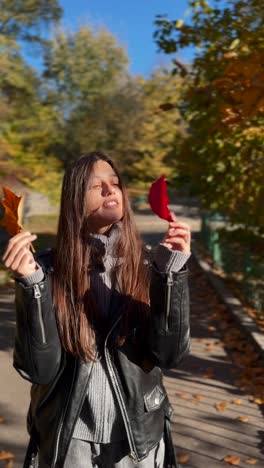 woman in park enjoying autumn leaves