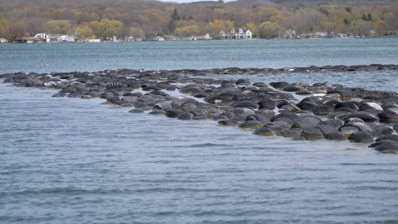 Row Of Floating Rubber Tires In Lake Michigan. Tracking Shot