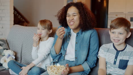children watching a movie and eating popcorn