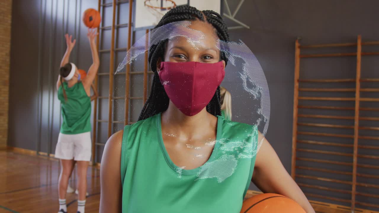 Spiller, der holder en basketball og starter globe spinning-overlay og viser maske i sportstræning