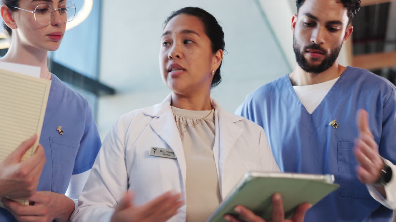 Diverse Medical Team Discussing Patient Information on a Digital Tablet