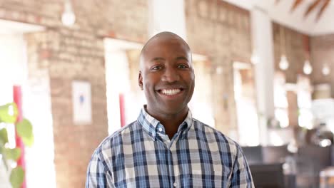 Portrait-of-happy-african-american-casual-businessman-in-creative-office-in-slow-motion