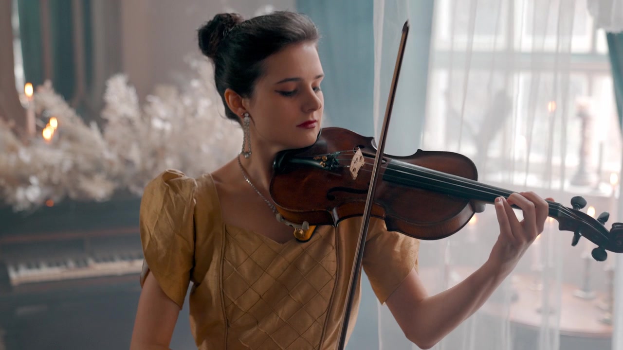Giovane donna elegante che suona il violino in un ambiente classico