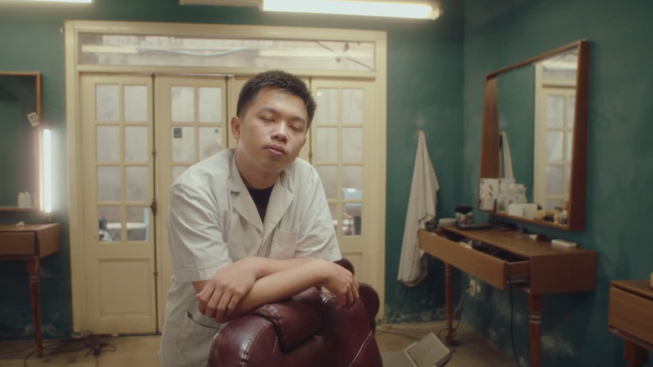 Young Asian Barber Posing on Camera in the Hairdressing Salon