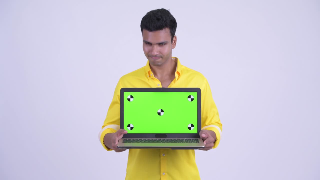 joven y guapo hombre de negocios indio con una computadora portátil