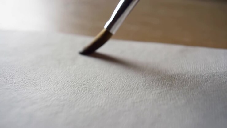 Brush painting on paper, in flat surface, with paper, brush, with paper, brush texture, from a top-down perspective, with white, brown accents, and neutral mood, clear detail, natural detail.