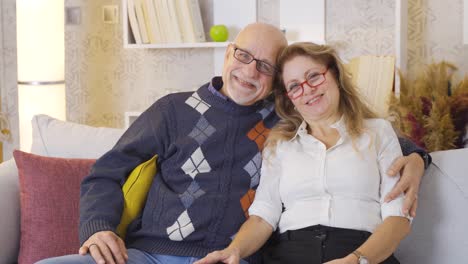 una pareja de ancianos felices y lindos mirando a la cámara.