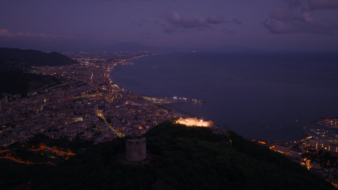 Illuminated Arechi Castle At Night Atop Monte Bonadies In The City Of Salerno, Italy. Aerial Drone Shot