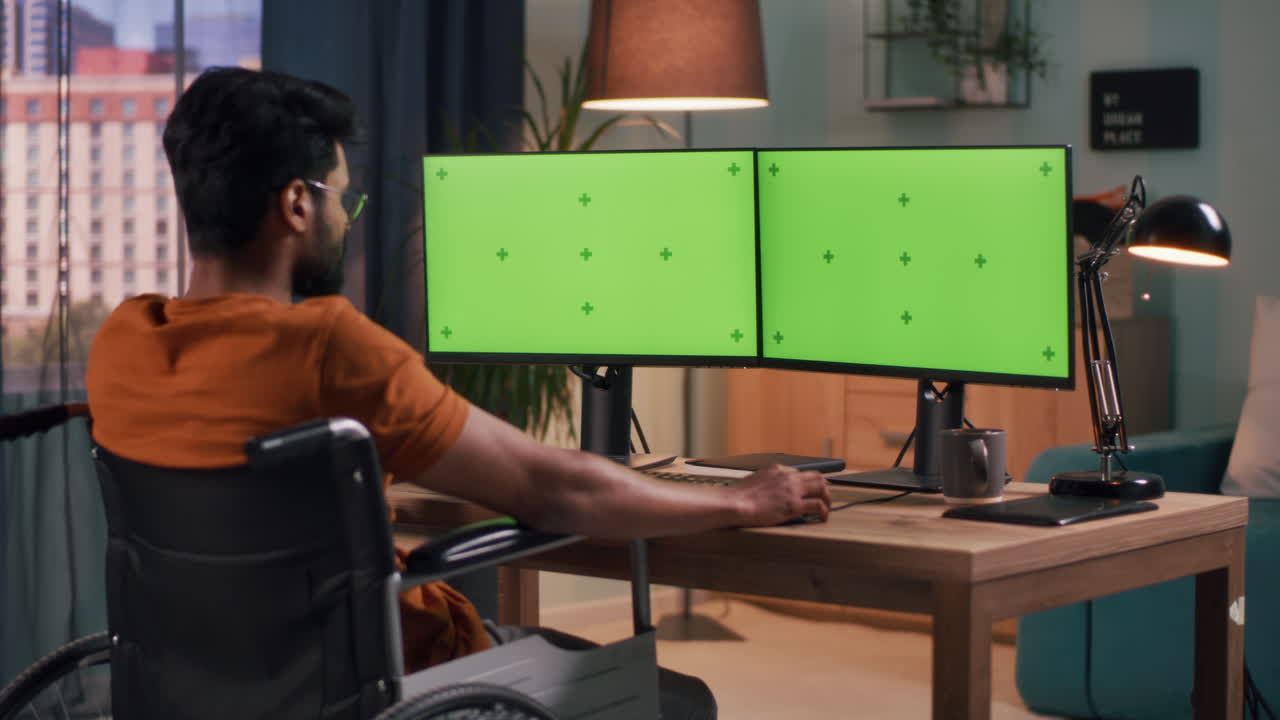 Person in Wheelchair Working at a Home Office with Dual Monitors