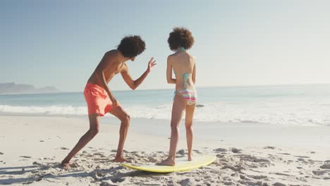 amigos entrenando estilo de surf en la arena