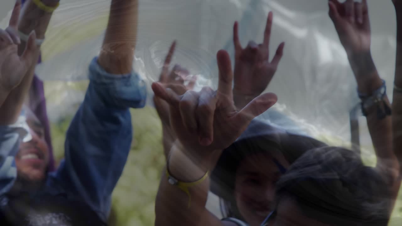 Group raising arms outside, hands initiating ripples in wavy overlay and purple ribbon for business