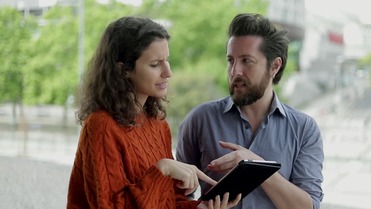 pareja hablando y usando una tableta digital juntos