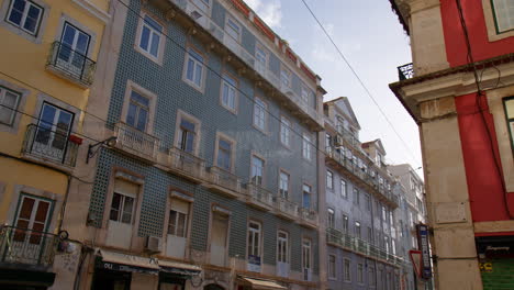 Fachadas-Cubiertas-Por-Azulejos-Desgastados-Y-Azules-En-La-Calle-De-Lisboa,-Portugal