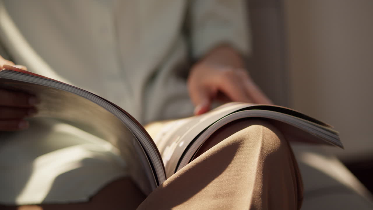 A person enjoys flipping through a magazine in a warm cozy living room.