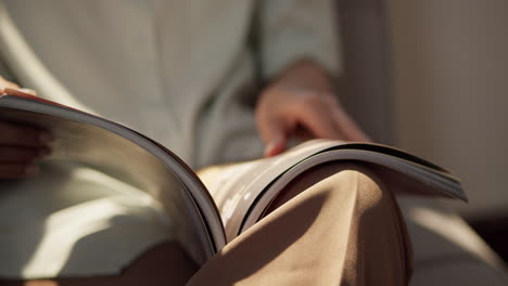 a person enjoys flipping through a magazine in a warm cozy living room.