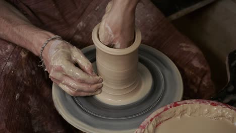 the potter makes a jug of clay. ceramist. a man makes a vase on a potter's wheel