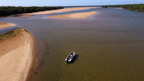 Disparo-De-Un-Dron-Siguiendo-Una-Pequeña-Lancha-Motora-Que-Conducía-Lentamente-A-Través-De-Aguas-Poco-Profundas-En-Las-Islas-Apipé-En-Corrientes,-Argentina.