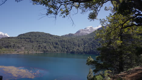 a scenic beauty of a river named arrayanes located in parque nacional los alerces, we can find the blue sky with a mountain in the background