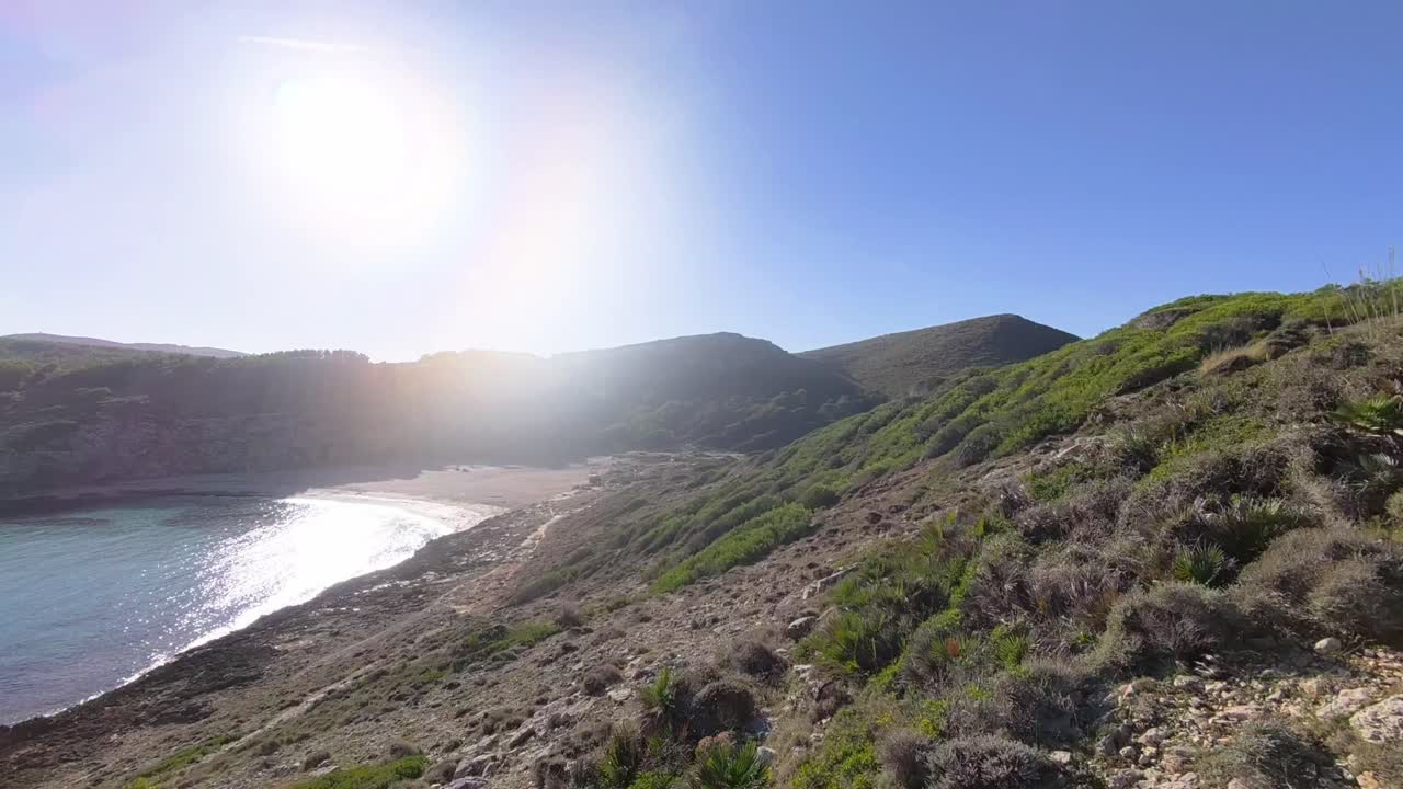 Luftfoto af Cala Torta-stranden og kystbjergene på Mallorca.