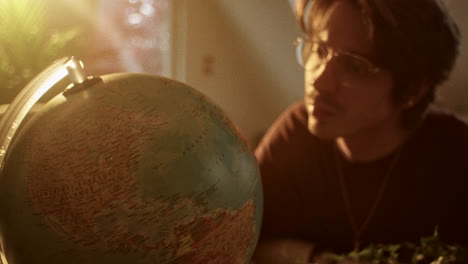 man looking at a globe