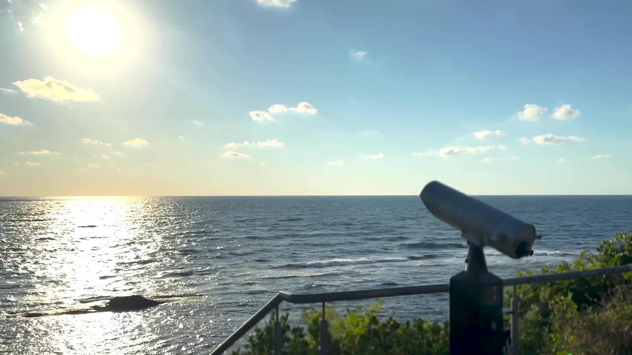 Sightseeing binoculars overlooking the sea at sunrise, panoramic ocean horizon view from an empty coastal observation deck, peaceful golden morning landscape. Scene B.