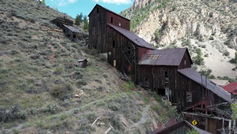 edificio abandonado de una mina y un molino en altas montañas - ascenso aéreo