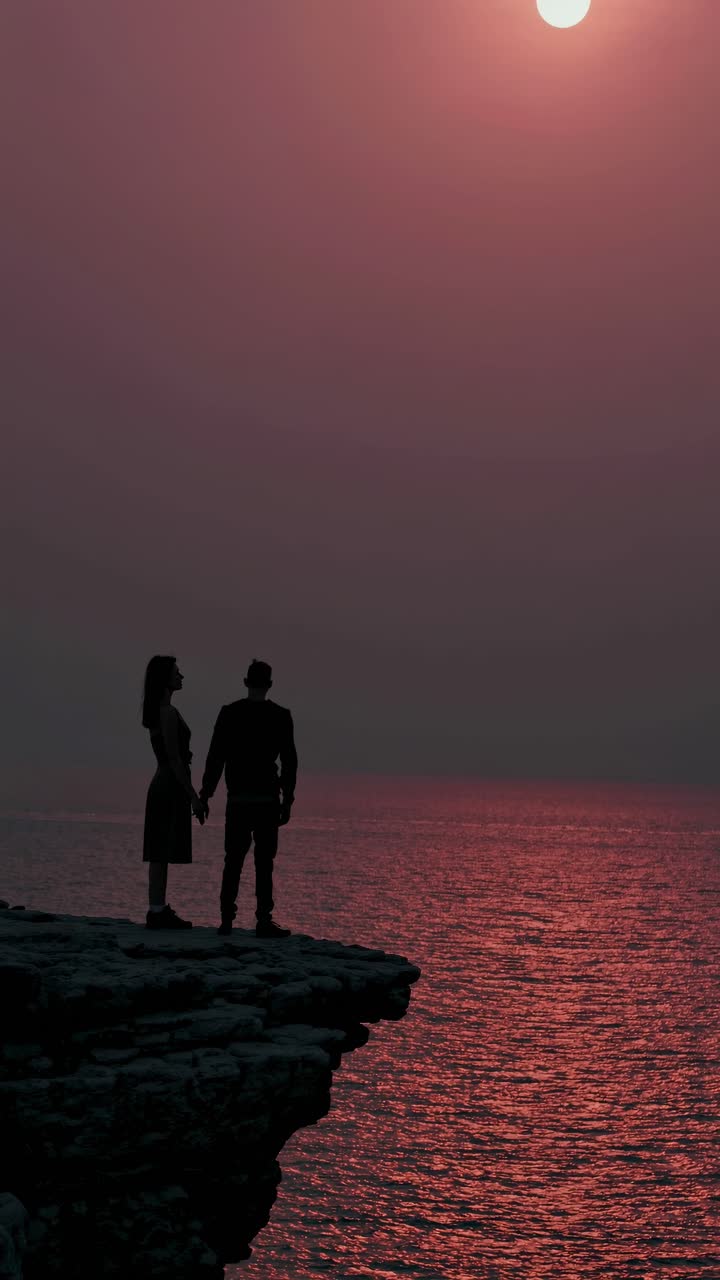 해가 지는 절벽 에 있는 부부