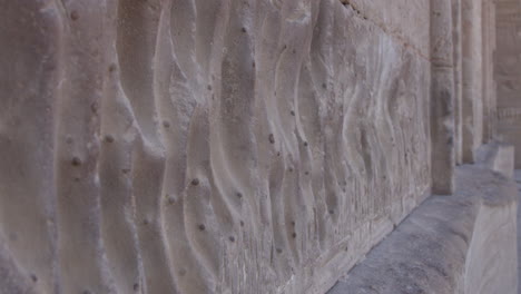 ancient stone carvings, intricate patterns and textures on a weathered wall in dendera