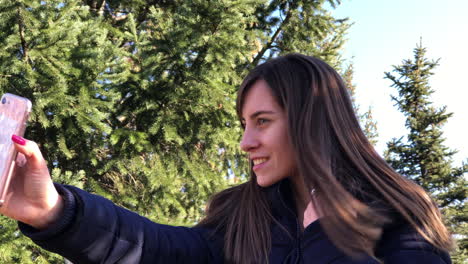 young girl taking selfies with a smartphone using front camera in a city park