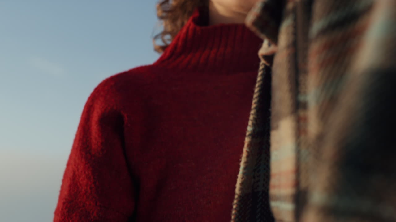 해변에 서 있는 세련된 커플. 꿈꾸는 여자와 남자가 카메라에 포즈를 취하고 있다.