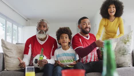 multi-generation family cheering while watching sports on tv at home