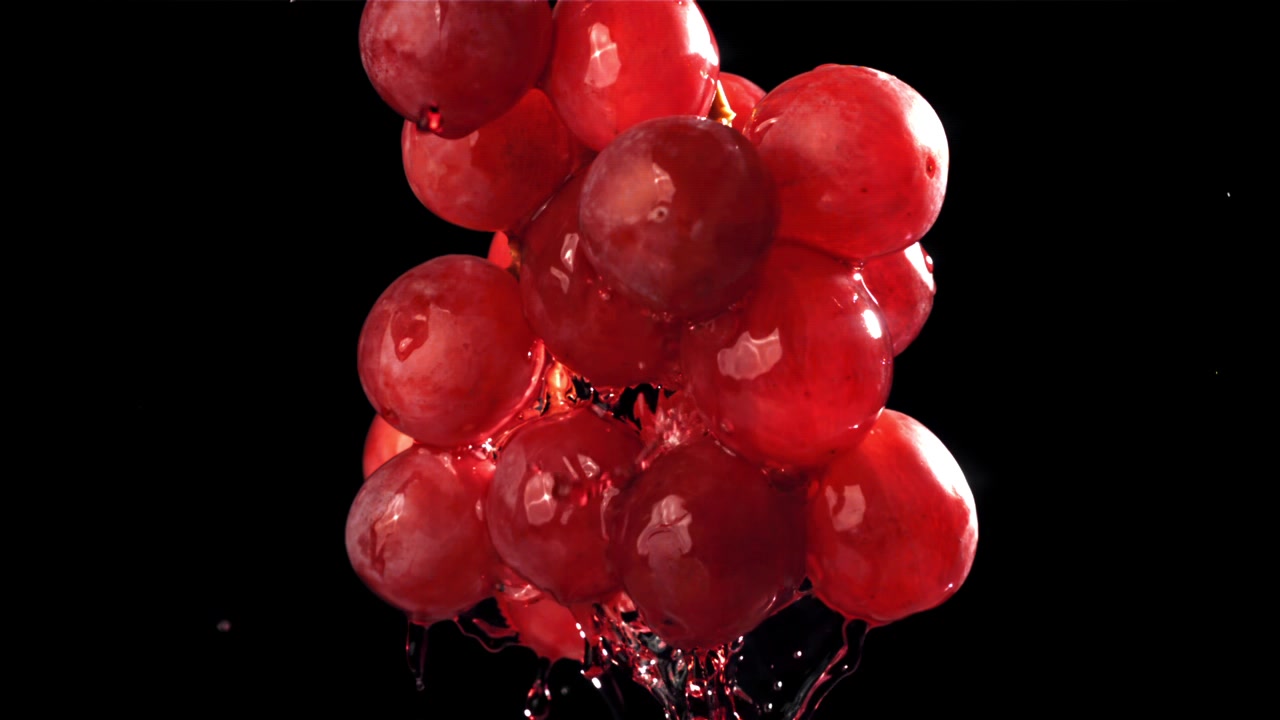 Uva rossa fresca con schizzi d'acqua al rallentatore