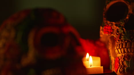 cerca de la naturaleza muerta de cráneos decorados iluminados por velas celebrando la fiesta mexicana de dia de muertos o día de los muertos