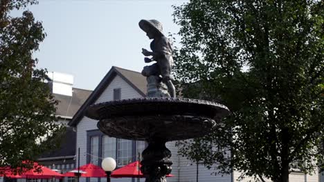 side view of a boy statue on top a fountain low angle on a sunny day